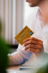 Person holding a credit card, representing a first credit card for someone with no UK credit history