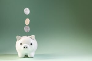 Coins falling into a piggy bank representing a Junior ISA savings for a child